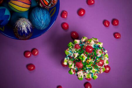 half frame, blue plate with celebration multicolored painted easter eggs, red sugar candies,...