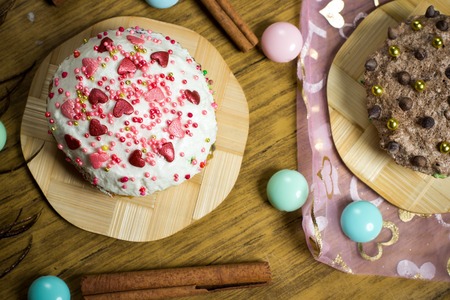 Celebrating sweet cupcakes, with sugar dots and hearts, cinnamon decoration, candies on wooden...
