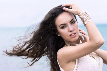 Beautiful young brunette woman outdoors portrait near the seaの写真素材