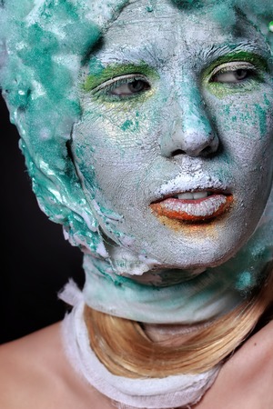 Portrait beautiful woman with creative makeup. Face mask of clay, looking like a statue, cracks on faceの写真素材