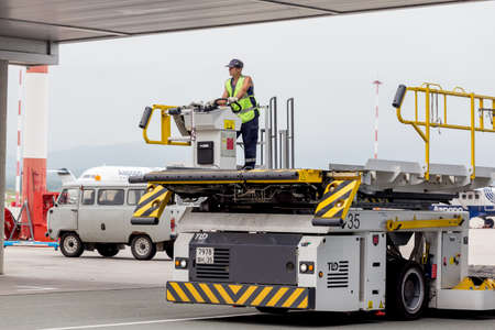 Russia, Vladivostok, 08/10/2018. Airport service car to carry passengers' luggage. Such cars are used to transport luggage to plane and vice versa. Transportation and equipment of airport.のeditorial素材