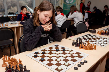 Russia, Vladivostok, 12/01/2018. Kids play chess during chess competition in chess club. Education, chess and mind games. Competition and tournament. Kids' leisure.のeditorial素材