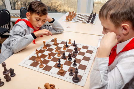Russia, Vladivostok, 12/01/2018. Kids play chess during chess competition in chess club. Education, chess and mind games. Competition and tournament. Kids' leisure.のeditorial素材