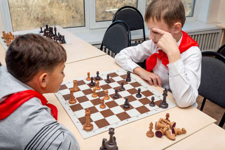 Russia, Vladivostok, 12/01/2018. Kids play chess during chess competition in chess club. Education, chess and mind games. Competition and tournament. Kids' leisure.のeditorial素材