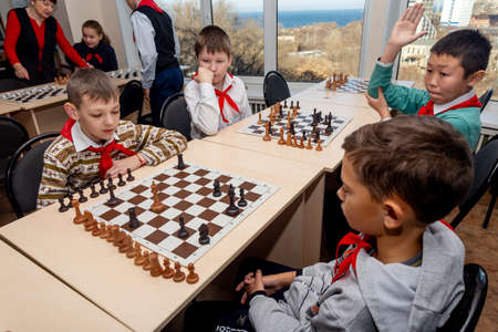Russia, Vladivostok, 12/01/2018. Kids play chess during chess competition in chess club. Education, chess and mind games. Competition and tournament. Kids' leisure.のeditorial素材
