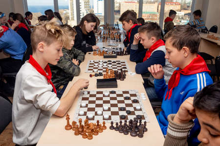 Russia, Vladivostok, 12/01/2018. Kids play chess during chess competition in chess club. Education, chess and mind games. Competition and tournament. Kids' leisure.のeditorial素材