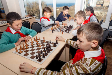 Russia, Vladivostok, 12/01/2018. Kids play chess during chess competition in chess club. Education, chess and mind games. Competition and tournament. Kids' leisure.のeditorial素材
