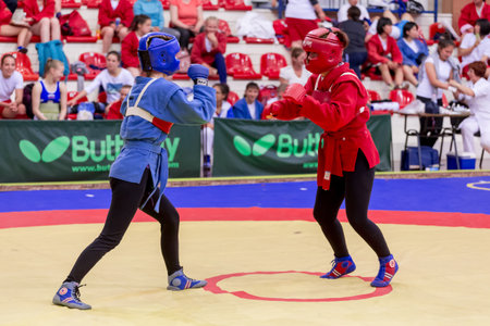 Russia, Vladivostok, 06/30/2018. Women self-defense show. Fighters in protective helmets box against each other. Wrestling, fighting sports and self-defense for women and usual people.のeditorial素材