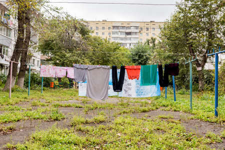 Laundry dries on the rope in the courtyard of Khrushchyovka. Khrushchyovka is a common type of old low-cost apartment building in Russia and post-Soviet space. house hold concept. Russia, Vladivostok.の写真素材