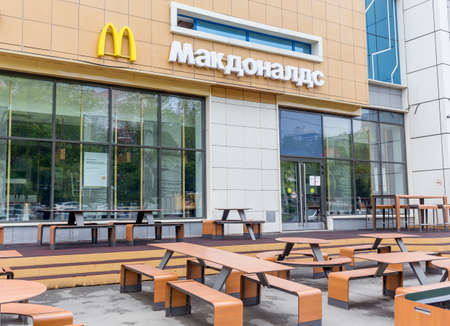 Russia, Vladivostok, May 25, 2022. Entrance to McDonald's restaurant without visitors. Empty tables in the front of the restaurant. McDonald's closed its cafes as sanctions for Russia's invasion of Ukraine.のeditorial素材