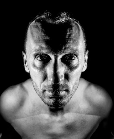 Stylish portrait of adult caucasian man with kind smile. Black and white shot, low-key lighting.の写真素材