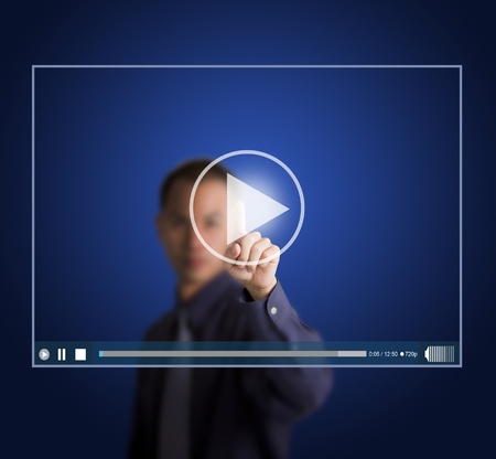 business man push start button on touch screen to run video clipの写真素材