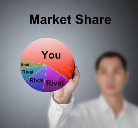 business man drawing pie chart showing market share of market leaderの写真素材