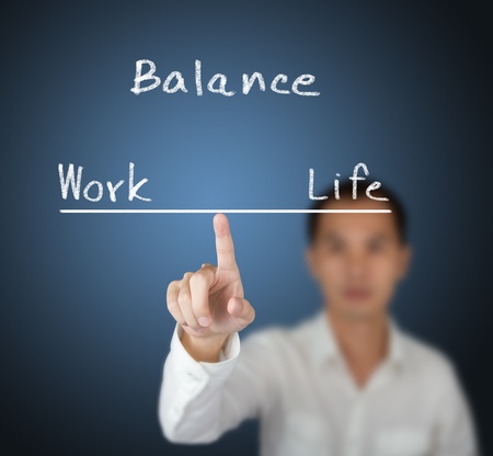 business man balance his work and life on finger tipの写真素材