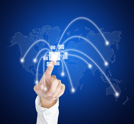 hand pressing touch screen sending mail to various region of the worldの写真素材