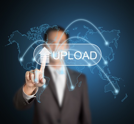 business man uploading digital file and information data to different destination in the world via computer network by pressing touchscreen buttonの写真素材