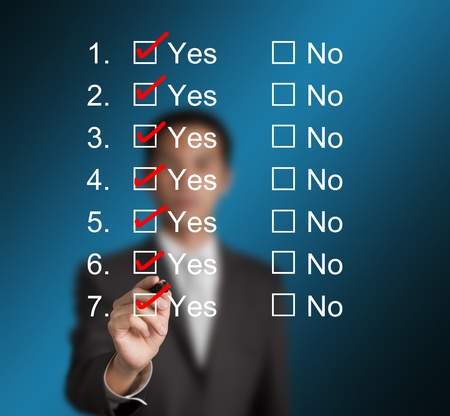 business man answering questions by make red mark on all yesの写真素材