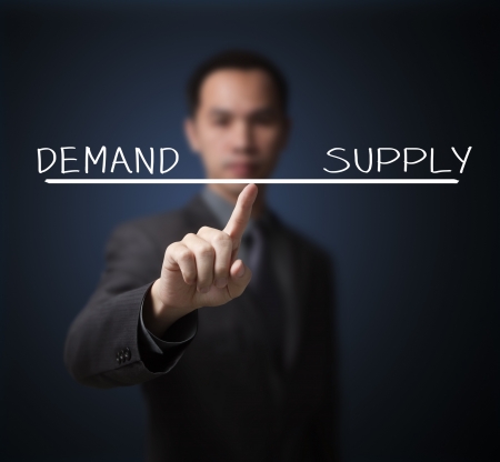 business man balance demand and supply on finger tipの写真素材