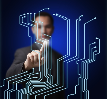 business man pointing at virtual electronic circuit board on computer touchscreenの写真素材