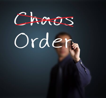 business man eliminate chaos and make orderの写真素材