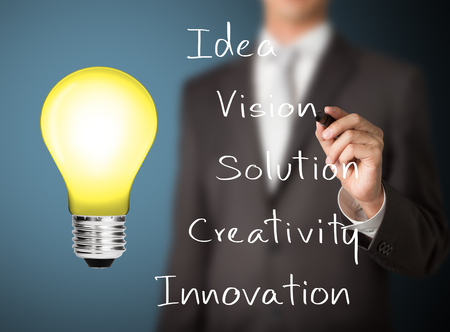business man writing meaning of light bulb signの写真素材