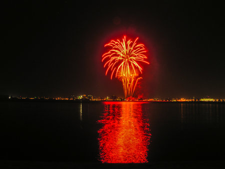 fireworks in the night sky, reflecting in the waterの写真素材