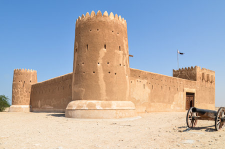 External view of the historical Al Zubarah fort in Qatar with an cannon