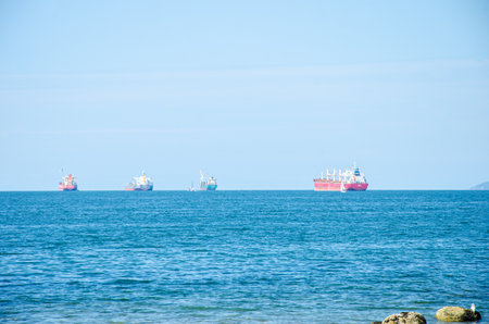 Ships in the approaching a seaport with moutains in the background