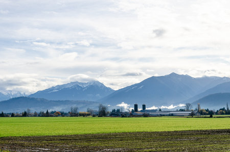 Beauriful View of rural canada on Highway from Abbotsford to Hope in  BC, Canada with snow capped mountains, low level clouds, valleys and farms in the backgroundの写真素材