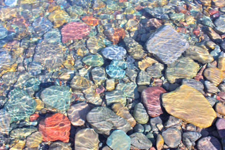 Colorful rocks under the water of McDonald Creek in Glacier National Park, Montanaの写真素材