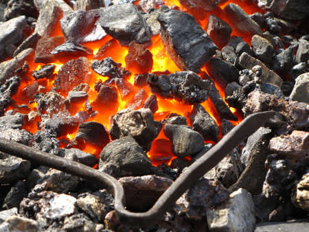Blacksmithing live coals with the pokerの写真素材