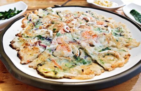 Korean style pizza with seafood on a large plateの写真素材