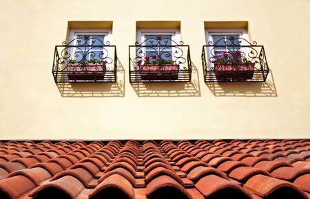 European style tile roof and windows with flowerpotsの写真素材