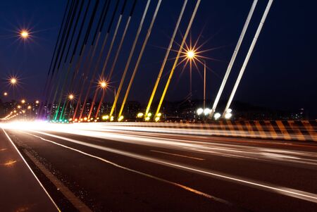 Traffic light traces on the cable-stayed bridge in nightの写真素材