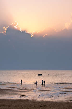 Cloudy sunset at the beach in time of tideの写真素材