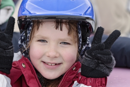 Happy smiling girl 8 years old in blue helmet on a skating-rinkの写真素材