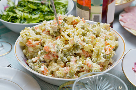 A salad bowl with Russian salad  salade Olivier  on a festive tableの写真素材
