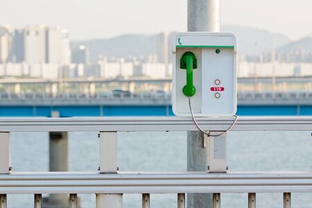 Emergency phone with a green handset on a bridge in Seoulの写真素材