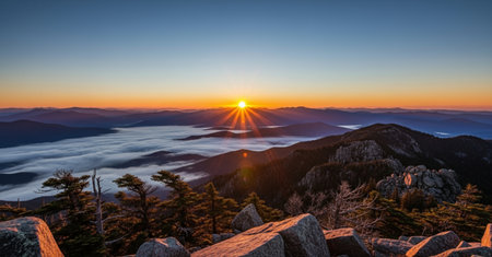 Sunrise in the mountains. Panoramic view of foggy valley.の素材