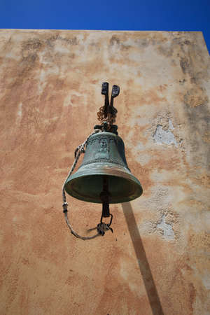 An old bell hanging on the wall of an Orthodox church on the island of Spinalonga.の写真素材