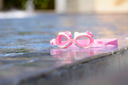 The swimming glasses are placed beside pool.の写真素材
