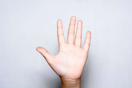 Girl raising five fingers up on hand on white background.の写真素材