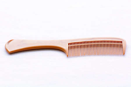 Brown hair comb on white backgroundの写真素材