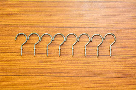 Cup hook screw on a wood background.の写真素材
