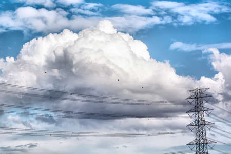 The blue cloudy sky and the high voltage.の写真素材