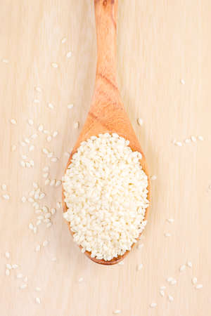 White sesame on the spoon on a wood background.の写真素材