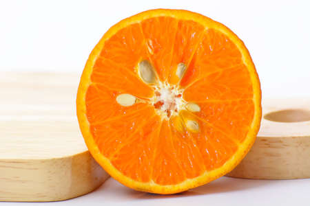 Orange shogun cut in half and cutting boards on a white background.