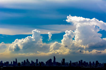 The blue cloudy sky & siluate building on bright natural background.の写真素材