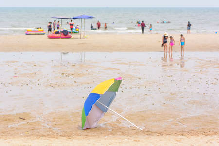 Multicolored umbrella on the beach and blur people.の写真素材