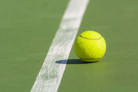 Green tennis balls are in a tennis court.の写真素材
